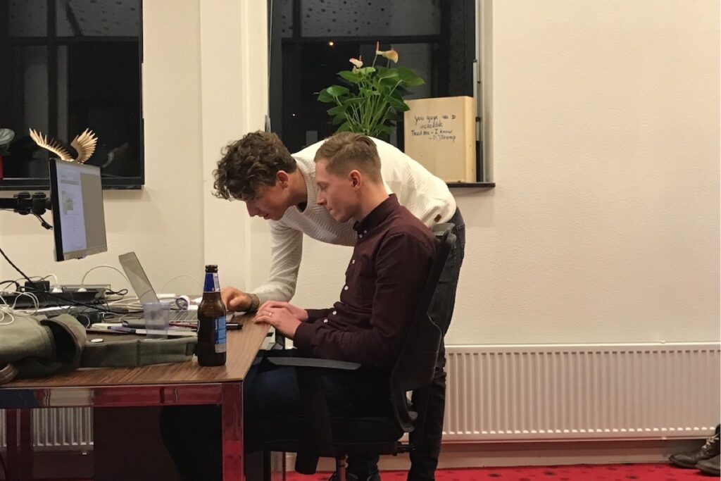 Foto van collega's hard aan het werk met een borreltje erbij.