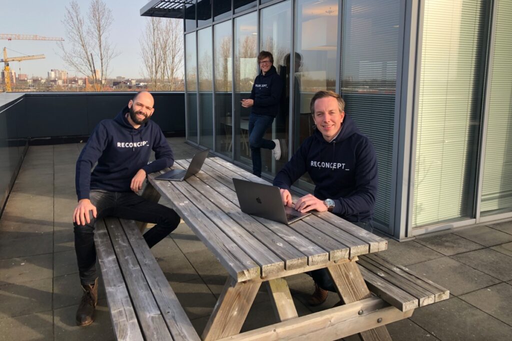 Foto van collega's aan het werk aan de picnicktafel in de legendarische Reconcept trui.