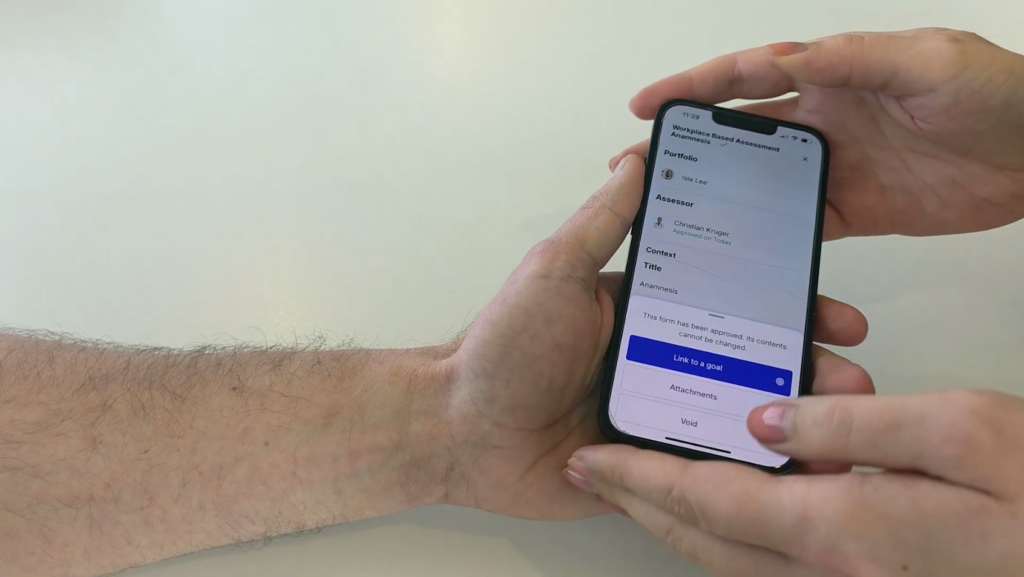 Een foto van handen die een telefoon vasthouden met de Reconcept applicatie ervoor.